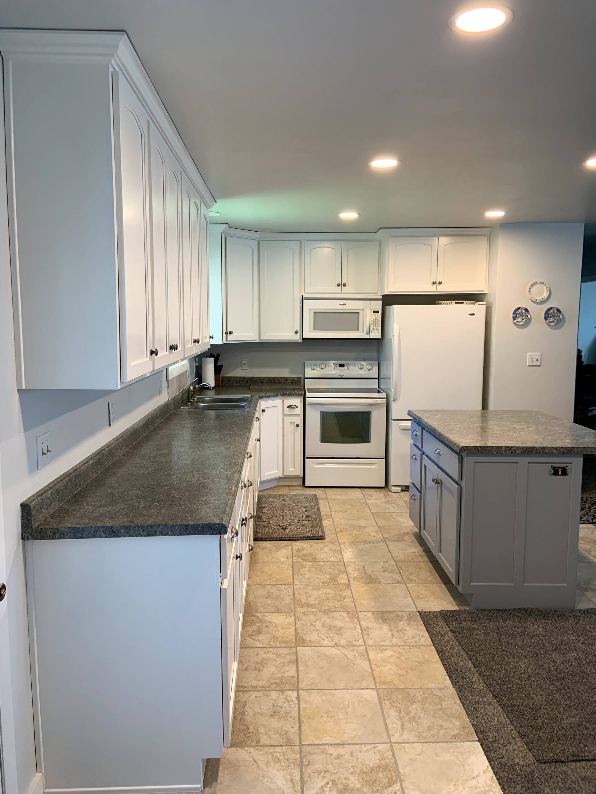 After photo of knotty wood cabinets in satin white with new doors and drawer fronts