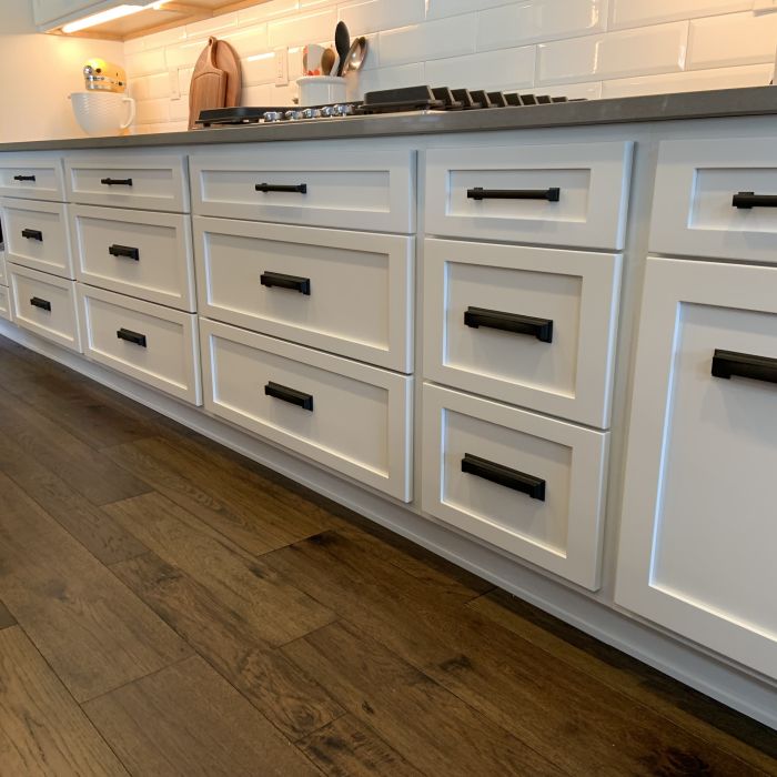New white bottom kitchen drawers with soft-close upgrade on dark wood flooring